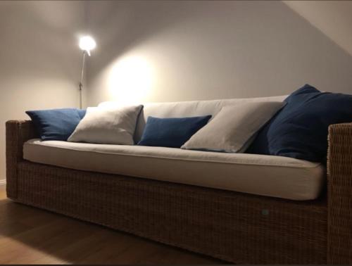 een bank met blauwe en witte kussens erop bij Lichtdurchflutete Dachgeschosswohnung in Uninähe in Oldenburg