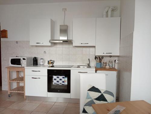 a kitchen with white cabinets and a stove top oven at Casa di Corte a Milano in Milan