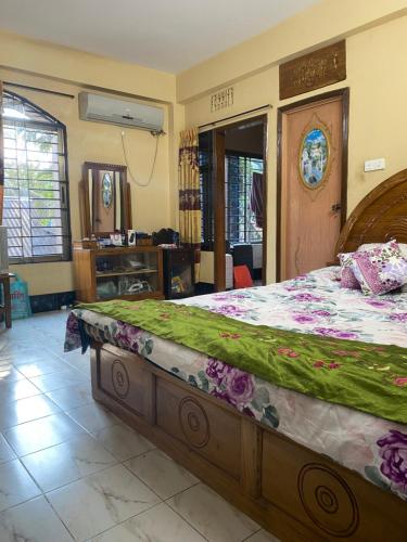 sypialnia z dużym łóżkiem z drewnianą ramą w obiekcie Holiday home in Sylhet (Kasobir) w mieście Kilsby