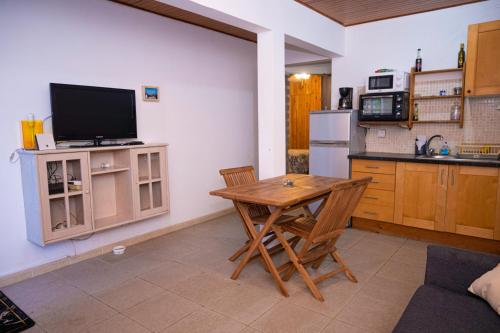 a kitchen with a wooden table and a television at JDREAMLOC in Kourou