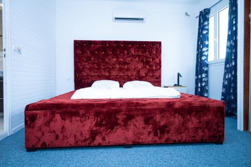 a red bed with a red headboard in a room at JDREAMLOC in Kourou