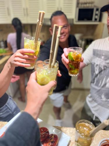 a group of people holding up drinks with wooden sticks at Villa Clarissa No. 8 in Las Terrenas