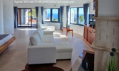 a living room with a white couch and a fireplace at Castelo do Mar, Madeira in Tábua