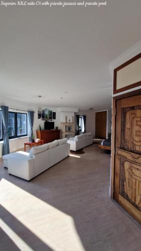 a large living room with white couches and a fireplace at Castelo do Mar, Madeira in Tábua