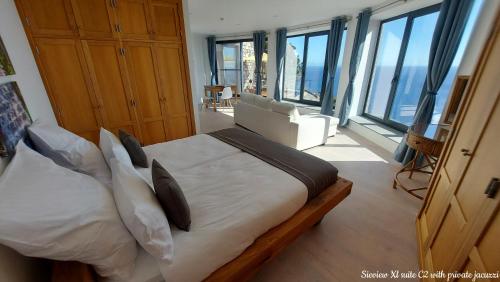 a bedroom with a bed with white sheets and pillows at Castelo do Mar, Madeira in Tábua