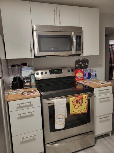 a kitchen with a stove and a microwave at Private Family Hideaway or Business Travel in Edmonton - 2 Bedroom Apartment in Edmonton