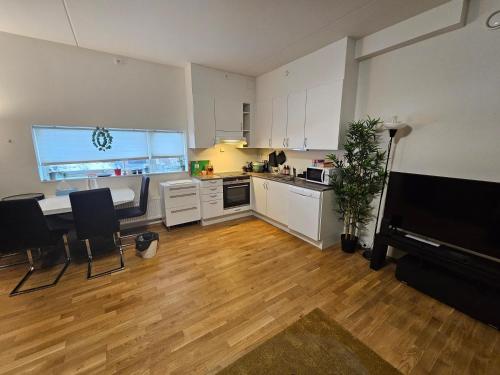 a kitchen with white cabinets and a table and a counter at Sjarmerende leilighet i Oslo in Oslo