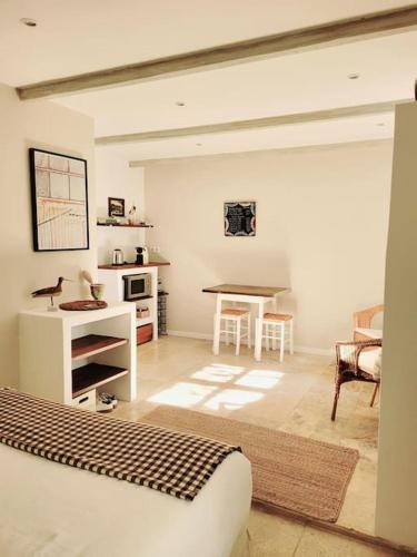 un salon avec un lit et une table dans l'établissement La maison blanche Intra-Muros Free parking, à Aigues-Mortes