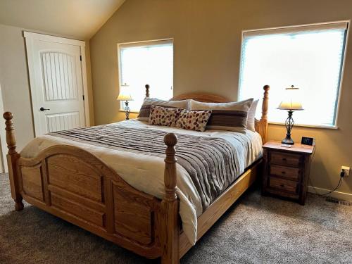 a bedroom with a large bed with two windows at Sweet Pea in Red Lodge