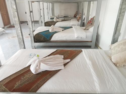 two beds with towels on them in a room at Janh Ya Phone Guesthouse in Pakbeng