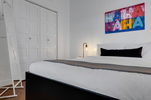 a bedroom with a large bed and a painting on the wall at LiV MTL Main in Montréal