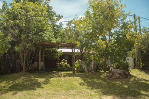 un jardín con pérgola y árboles en Compañeras, en La Pedrera