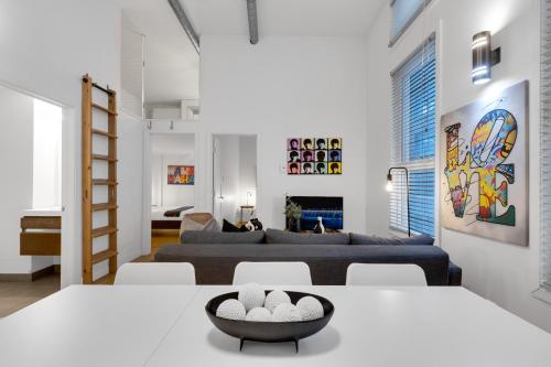 a living room with white walls and white tables and chairs at LiV MTL Main in Montréal