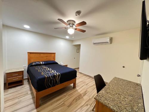 Hotel Catalina في تيخوانا: غرفة نوم بسرير ومروحة سقف