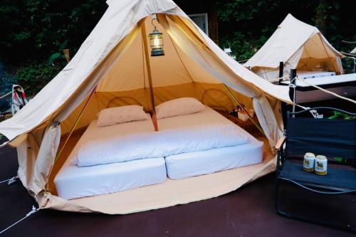 uma tenda com uma cama com duas almofadas em The camp Maekampong em Ban Pok Nai