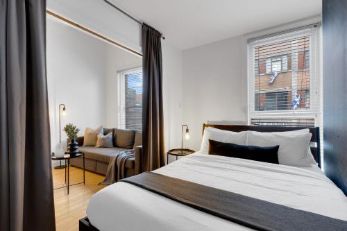 a bedroom with a bed and a couch at LiV MTL Main in Montréal