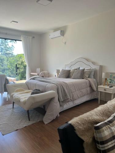a white bedroom with a large bed and a couch at Lake House_SC in Rio Forcação