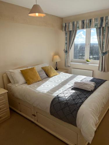 a bedroom with a large bed with a window at Cosy 3 bedroom house in Stoke on Trent