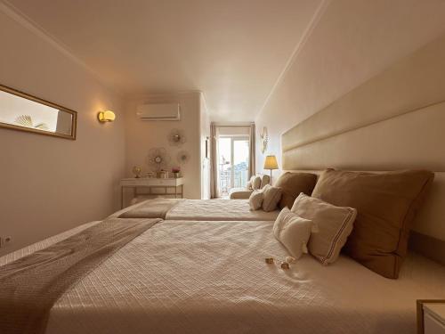 Deluxe Flat by Albufeira Holidays في ألبوفيرا: غرفة نوم بيضاء كبيرة مع سرير كبير مع الوسائد