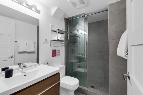 a bathroom with a shower and a toilet and a sink at LiV MTL Main in Montréal