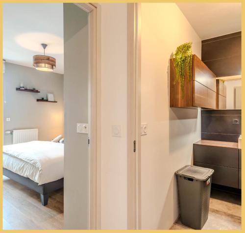 Habitación con dormitorio con cama y cubo de basura en Appart T3 Moderne Ambilly en Ambilly