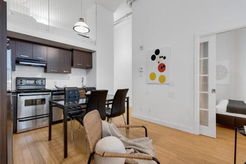 a kitchen and living room with a table and chairs at LiV MTL Main in Montréal