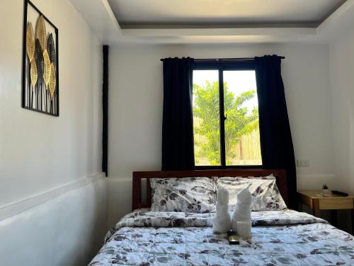 una camera con un letto e una finestra di Ô Calme Guesthouse a San Vicente