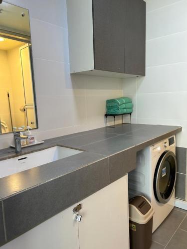 a kitchen with a sink and a washing machine at BS Homestay3 - 1 Bedroom Apartment in Miri Times Square in Miri