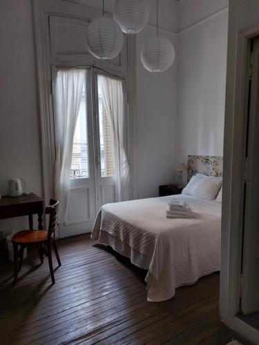 een witte slaapkamer met een bed en een raam bij Hotel europeo in Buenos Aires