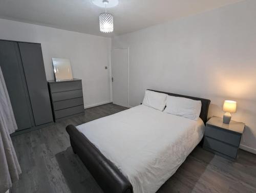 a bedroom with a large white bed and a television at 3 Bedroom Apartment Sleeps 8 in Edinburgh