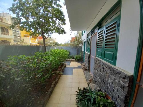 einen Gang neben einem Gebäude mit grünem Fenster in der Unterkunft My Place Apt#1 in Praia