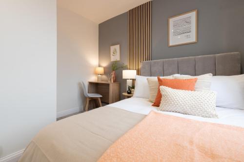 a bedroom with a large bed with orange and white pillows at Aviary Nest by Nordstay in Amley