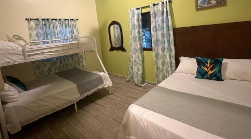 a bedroom with two bunk beds and a window at Villa Familiar con Piscina Privada y Rio in Bonao