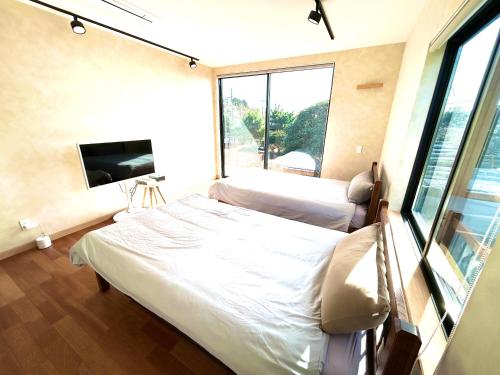 Habitación hospitalaria con 2 camas y TV en くろまま, en Oshima