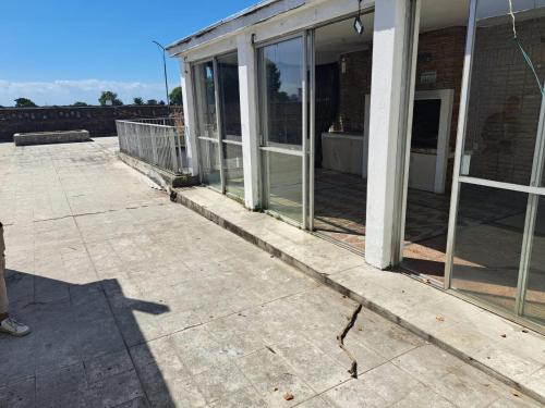 eine leere Terrasse mit Glastüren an einem Gebäude in der Unterkunft Casona con Barbacoa en Av princ in Montevideo