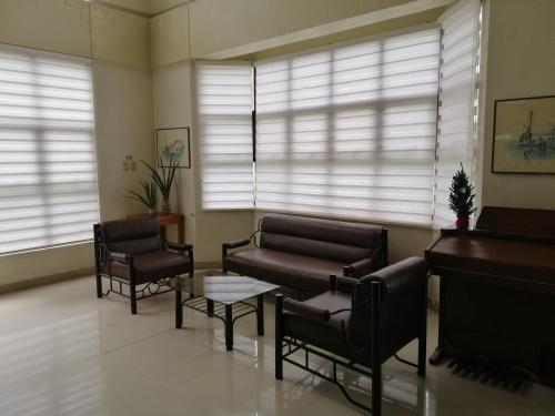 - un salon avec un piano, un canapé et des chaises dans l'établissement JD Homestays CDO, à Cagayán de Oro