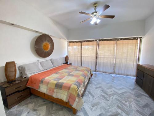 um quarto com uma cama e uma ventoinha de tecto em Dpto de lujo costera em Acapulco