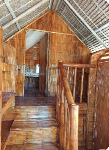 an empty room with wooden floors and wooden stairs at GoOd Inn White Beach Moalboal in Cebu City