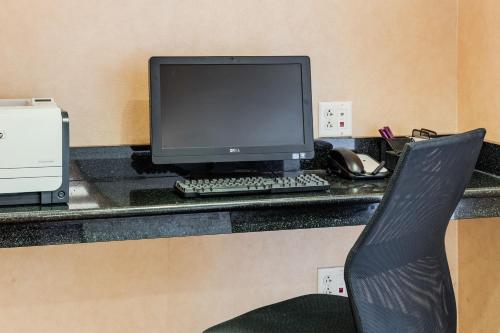 a desk with a computer monitor and a keyboard and mouse at Residence Inn by Marriott Auburn in Auburn