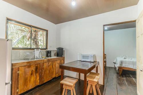 uma cozinha com uma mesa e um micro-ondas em Zion's Place em Nosara
