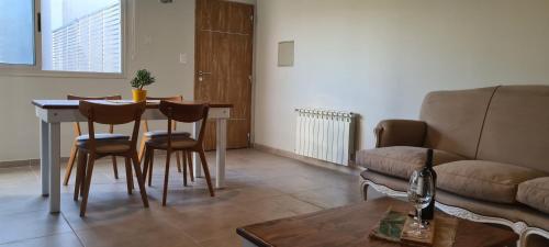 a living room with a table and chairs and a couch at Departamento Complejo Los Agaves - Chacras de Coria in Ciudad Lujan de Cuyo