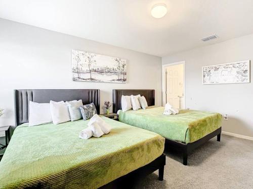 una camera con due letti con lenzuola verdi di Encanto at Auburndale ad Auburndale