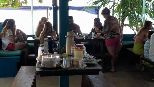 um grupo de pessoas sentadas às mesas de um restaurante em Beija Flor em Gamboa