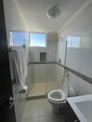Habitación con baño privado en un piso 24 con todo lo necesario في مدينة باناما: حمام ابيض مع مرحاض ودش