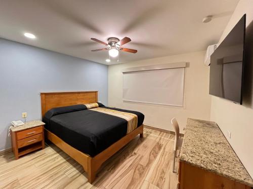a bedroom with a bed and a ceiling fan at Hotel Catalina in Tijuana
