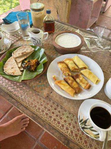 a table with two plates of bread and a cup of coffee at villa ovita in Talpe