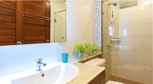 ein Bad mit einem Waschbecken, einem WC und einer Dusche in der Unterkunft Lasalle Park Serviced Apartment at Lasalle 75 in Bangna