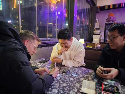 a group of men sitting around a table at Riverside International Youth Hostel阅江老院青年旅舍 in Chongqing