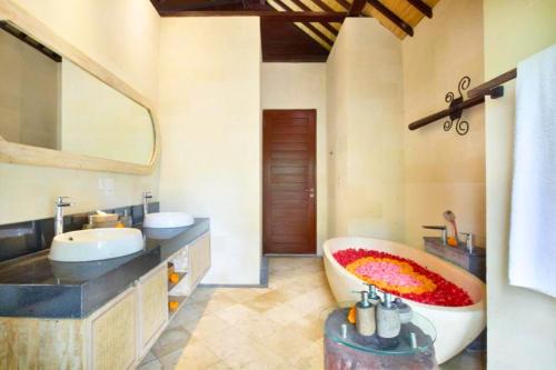 een badkamer met een bad, een wastafel en een spiegel bij Romance Forest view 2 BR Private Pool Villa ZN21 in Ubud