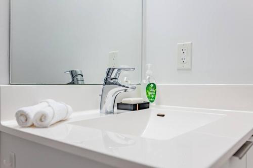 La salle de bains est pourvue d'un lavabo, d'un robinet et d'un miroir. dans l'établissement 660sqf Condo by Lake close to Airport, Parking!, à Toronto